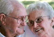Elderly couple smiling and embracing outdoors