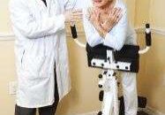 Elderly woman exercising with doctor's help