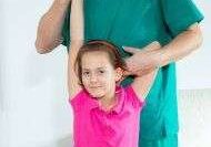 Healthcare professional helping child stretch arm