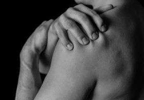 Hands touching bare shoulder in black and white