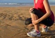 Woman kneeling on beach sand