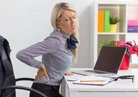 Person holding back in pain at work
