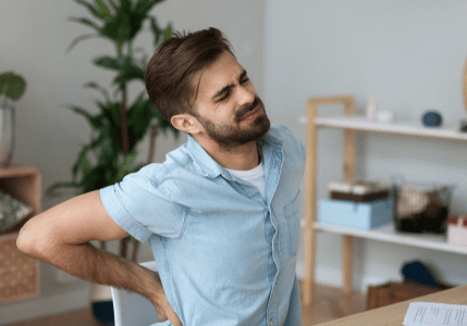 Man experiencing back pain in office