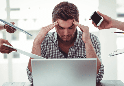 Overwhelmed employee at a busy desk